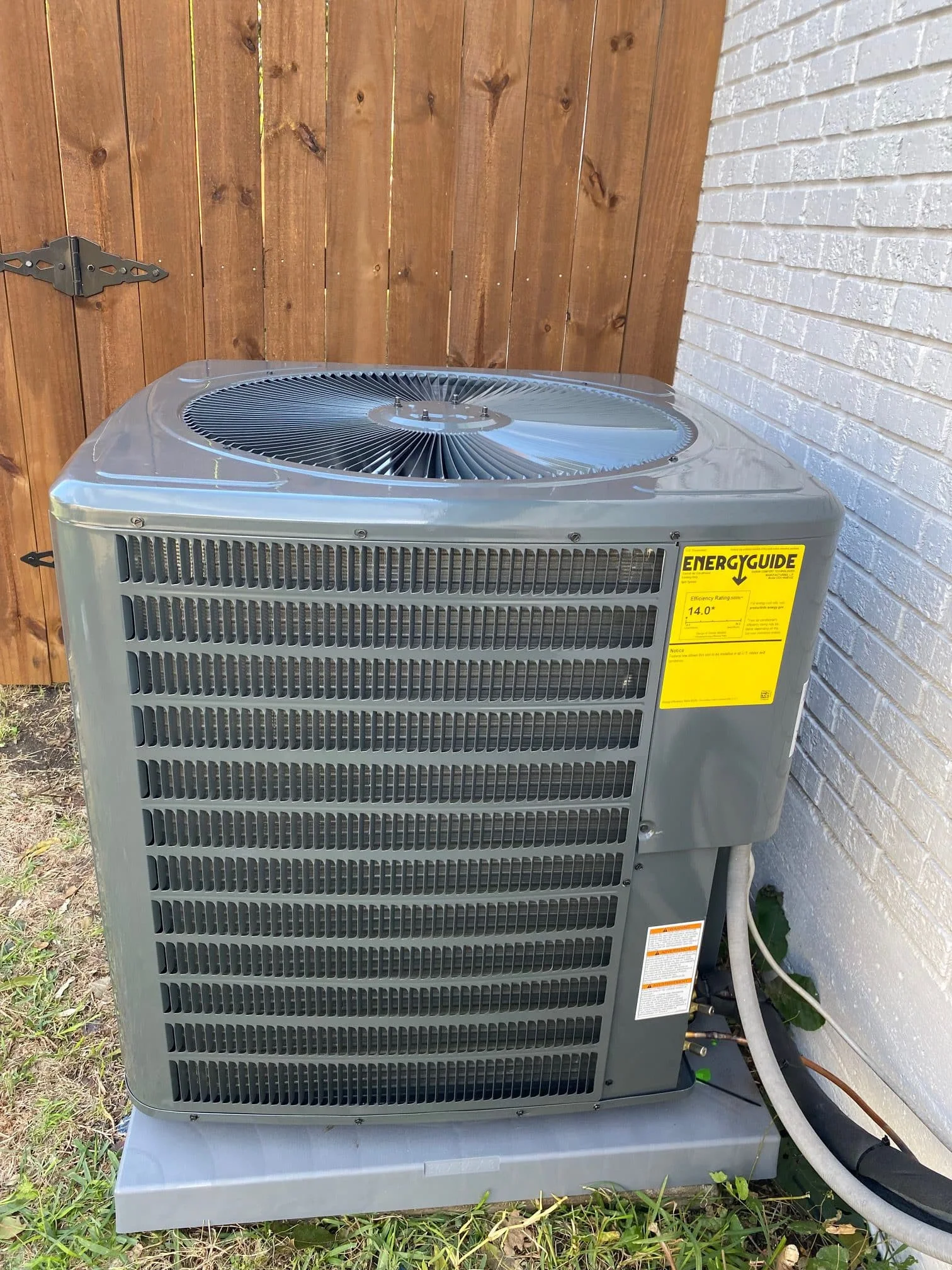 Side view of the installation of a Goodman condenser in Desoto, Texas