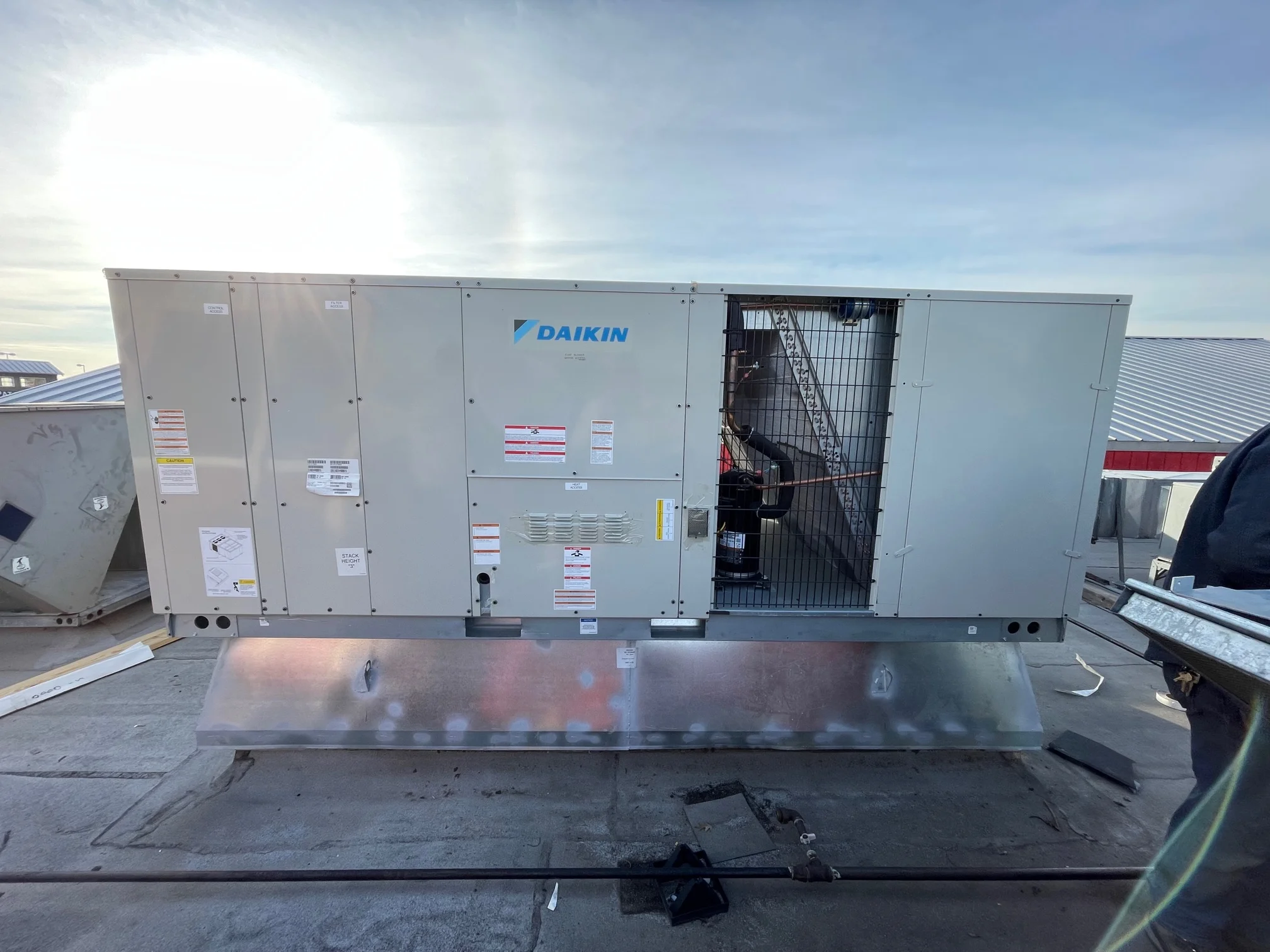 Completed installation of Daikin 15 ton commercial rooftop gas package unit with fabricated sheet metal curb adapter in Arlington, Texas